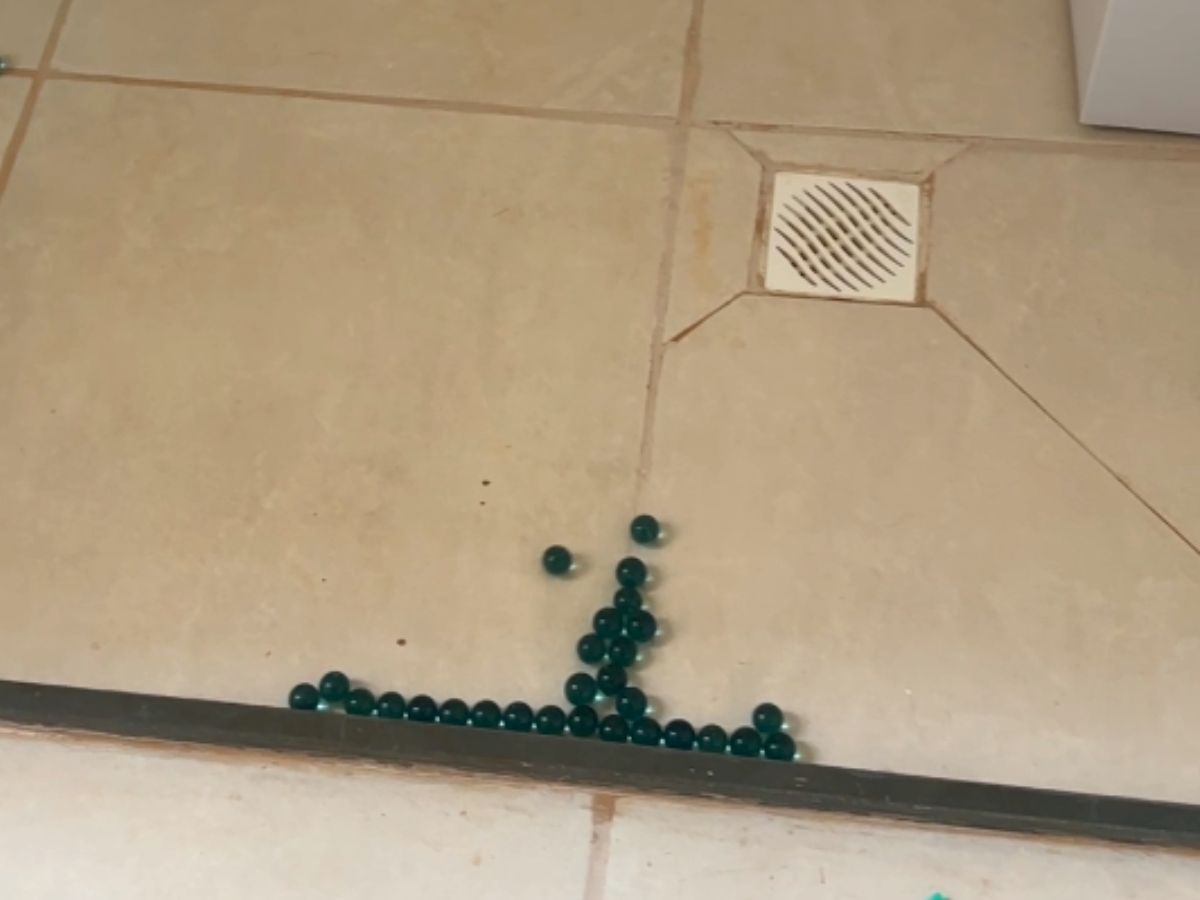 Bolinhas espalhadas pelo piso do banheiro, indicando caimento incorreto em direção ao ralo